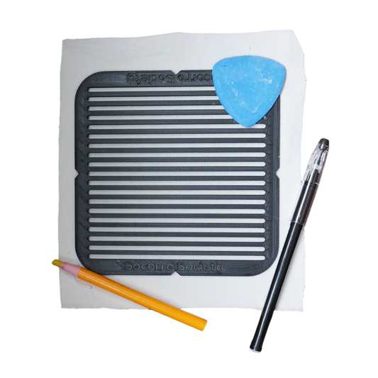 Silicone mat with a pen, pencil, and blue tool on a white background