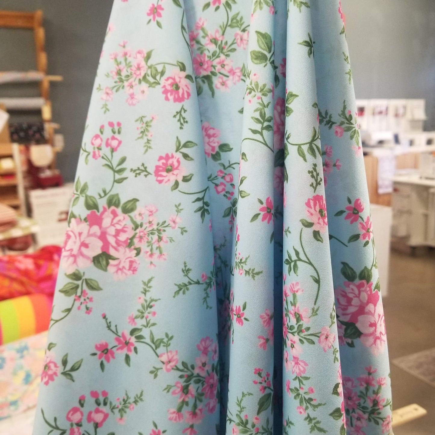 Floral-patterned fabric with pink flowers on a blue background