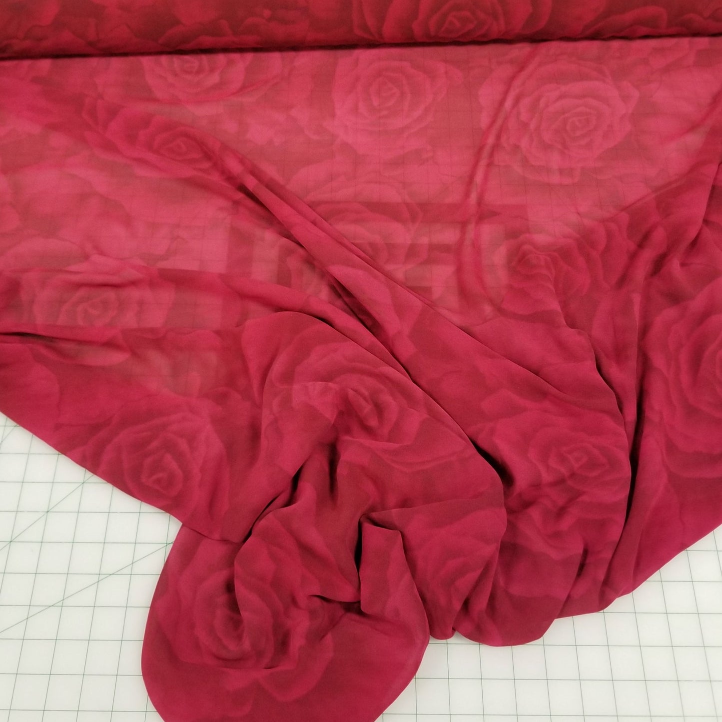 Roses Red fabric with a floral pattern on a white grid background. LA Finch Deadstock Fabric. Los Alamitos ,Ca