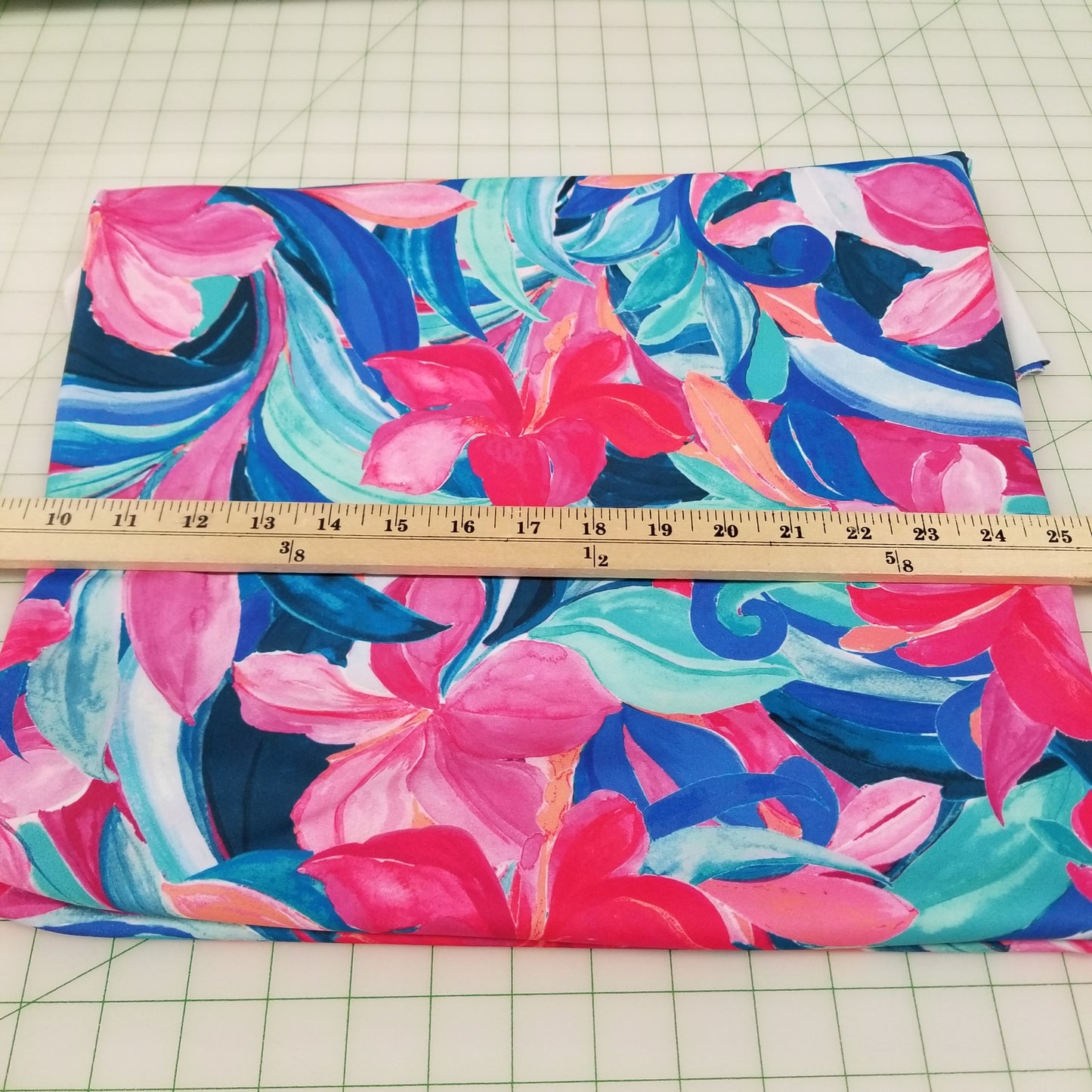 Colorful floral fabric with a ruler for scale on a grid background