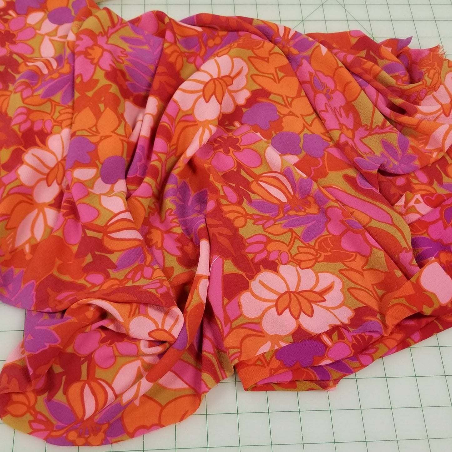 Floral fabric with pink and orange pattern on a grid background