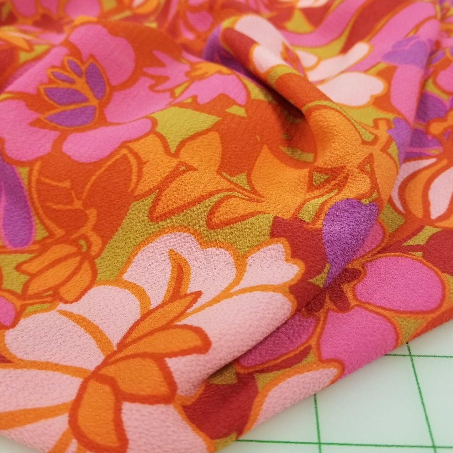 Colorful floral fabric on a green grid background