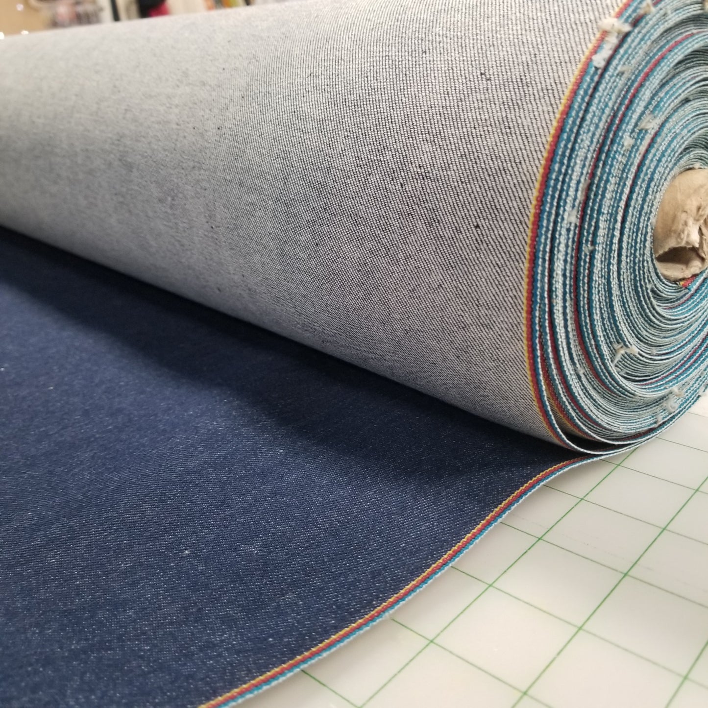 Roll of denim fabric with a grid background