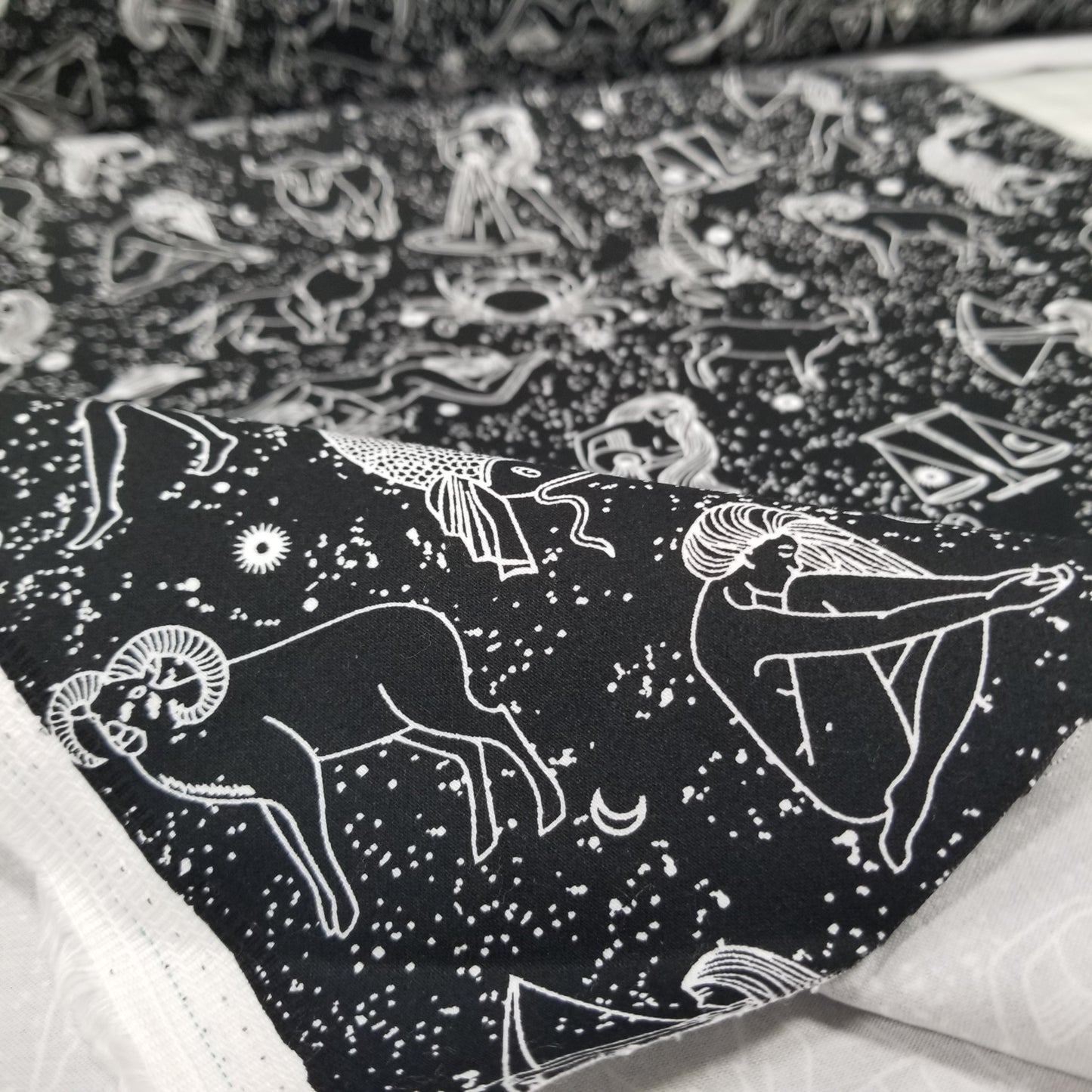 Black shirt with white astrological sign designs on a textured background