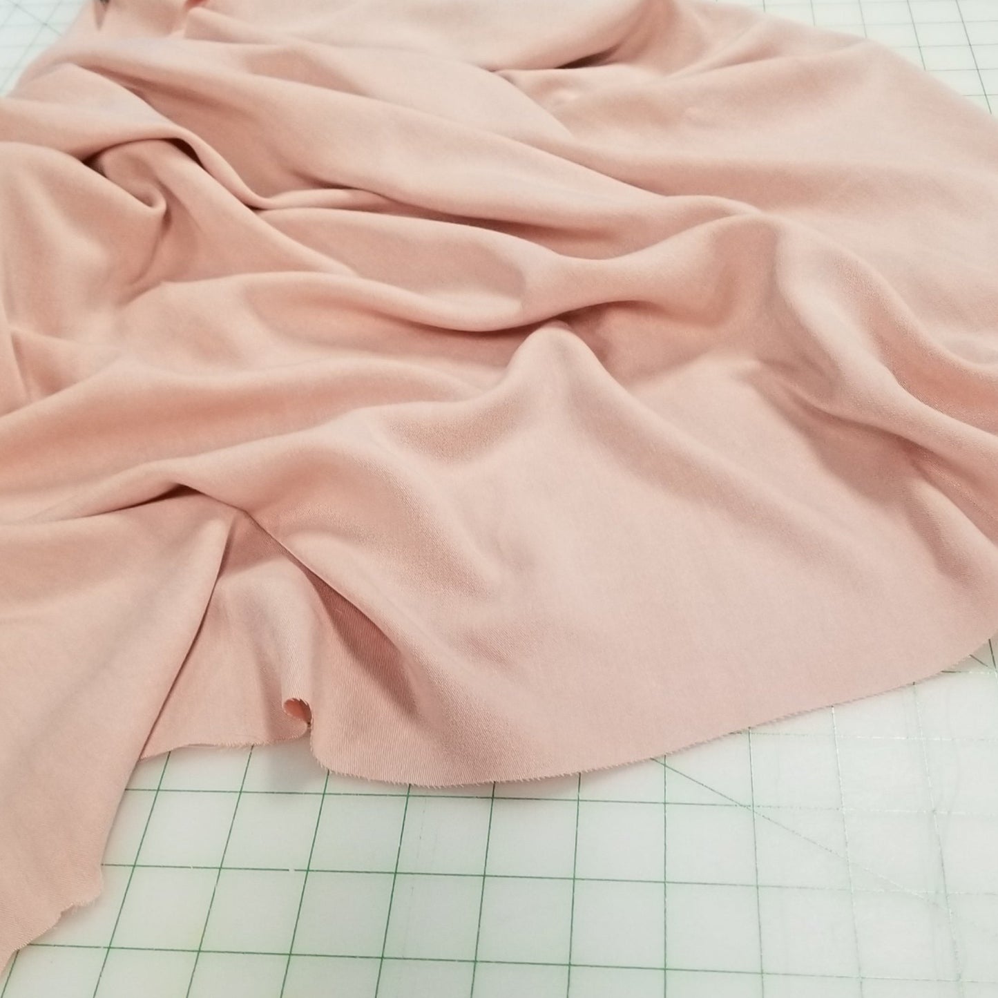 Pink fabric draped over a surface with a grid pattern in the background