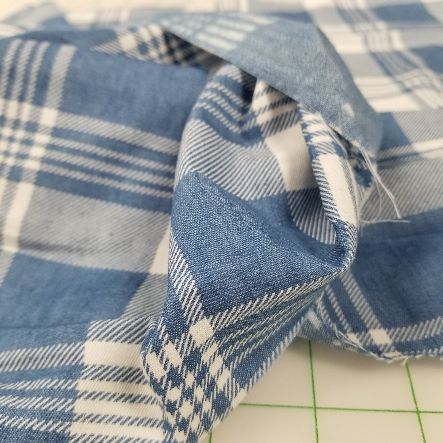 Close-up of blue and white plaid fabric on a grid background
