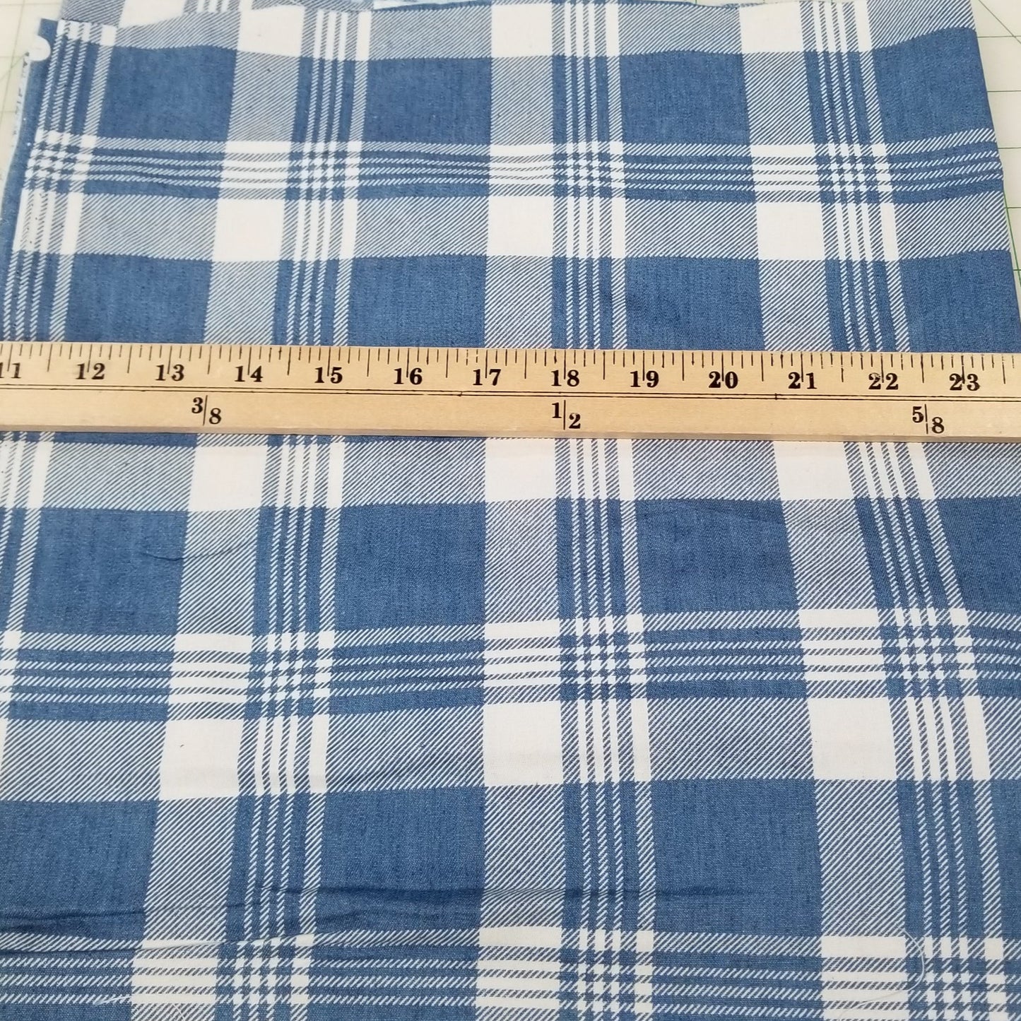 Blue and white checkered fabric with a ruler for scale on a grid background
