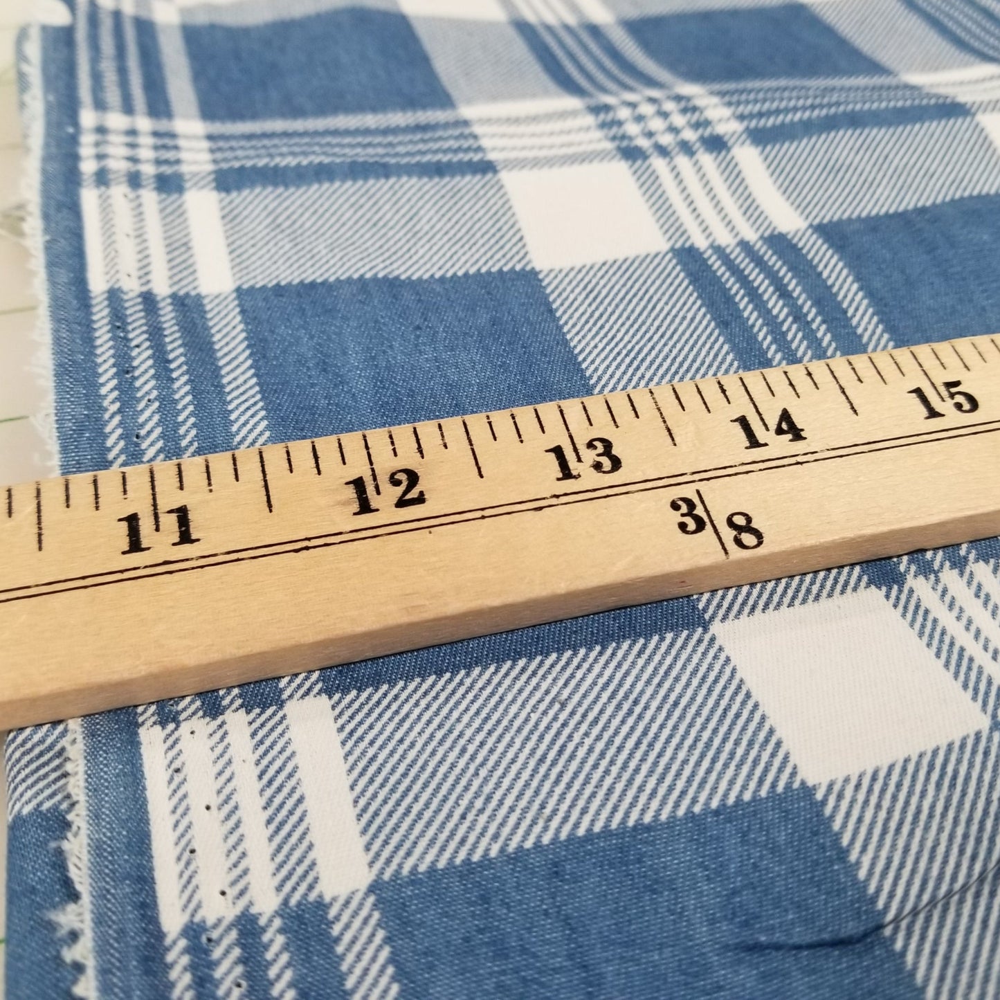 Blue and white checkered fabric with a wooden ruler for scale.