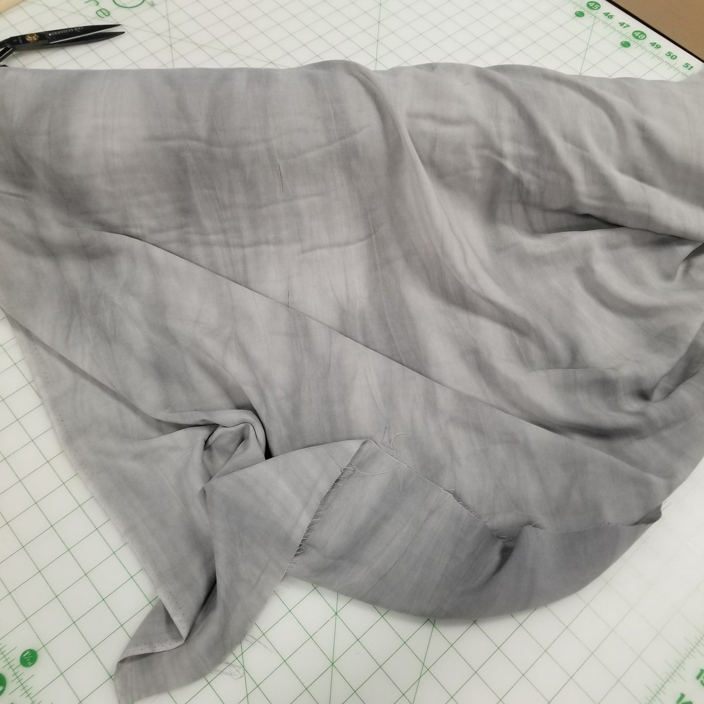 Gray fabric on a cutting mat with scissors