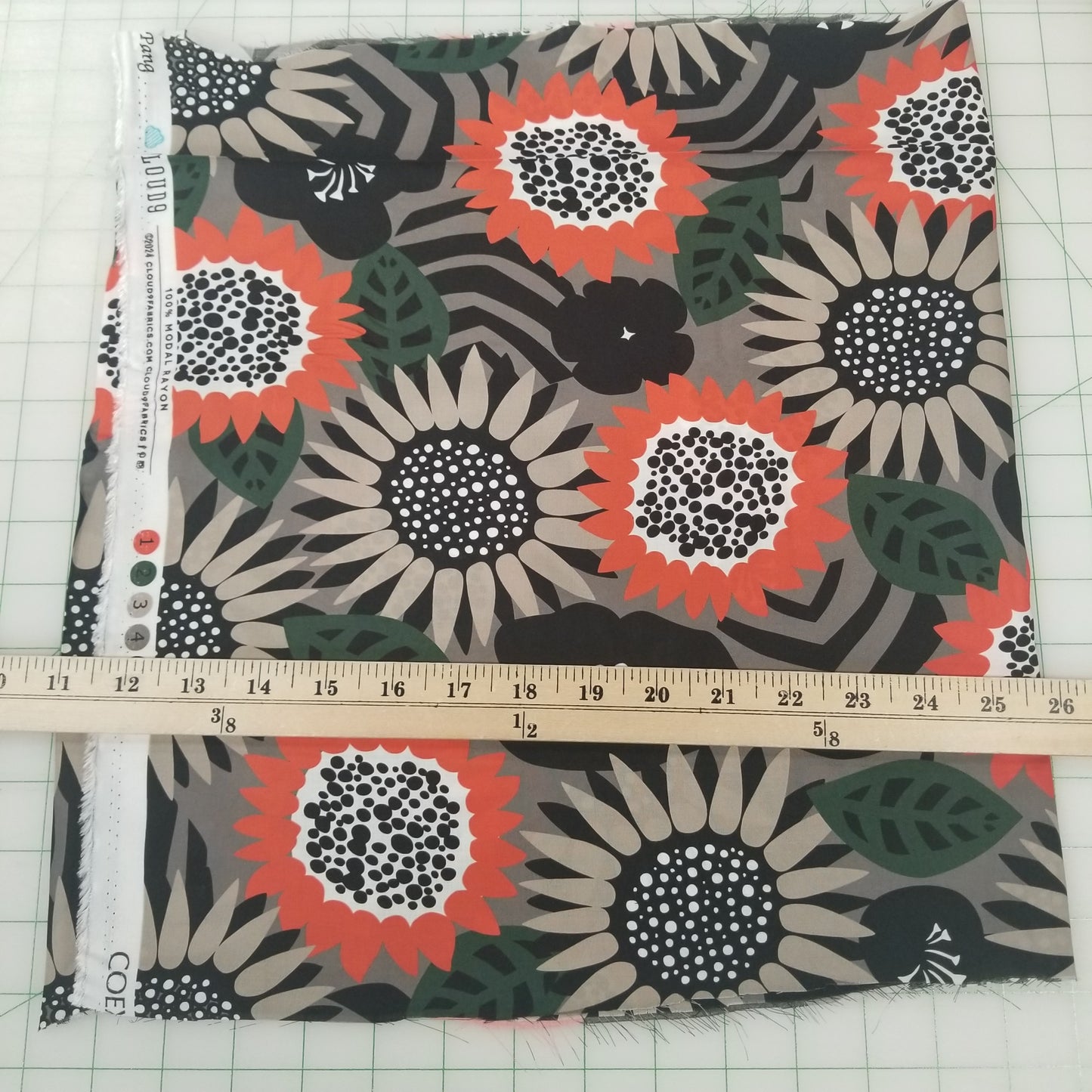 Floral fabric pattern with a ruler for scale on a grid background