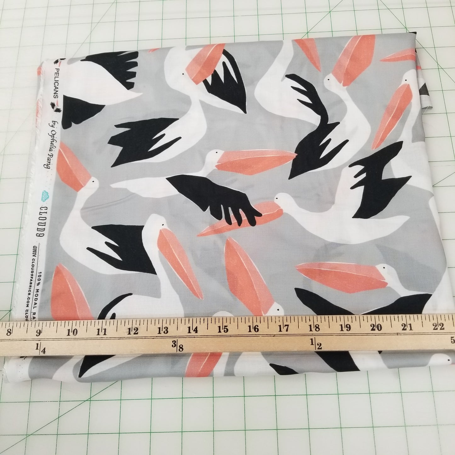 Fabric with pelican pattern and a ruler for scale on a grid background