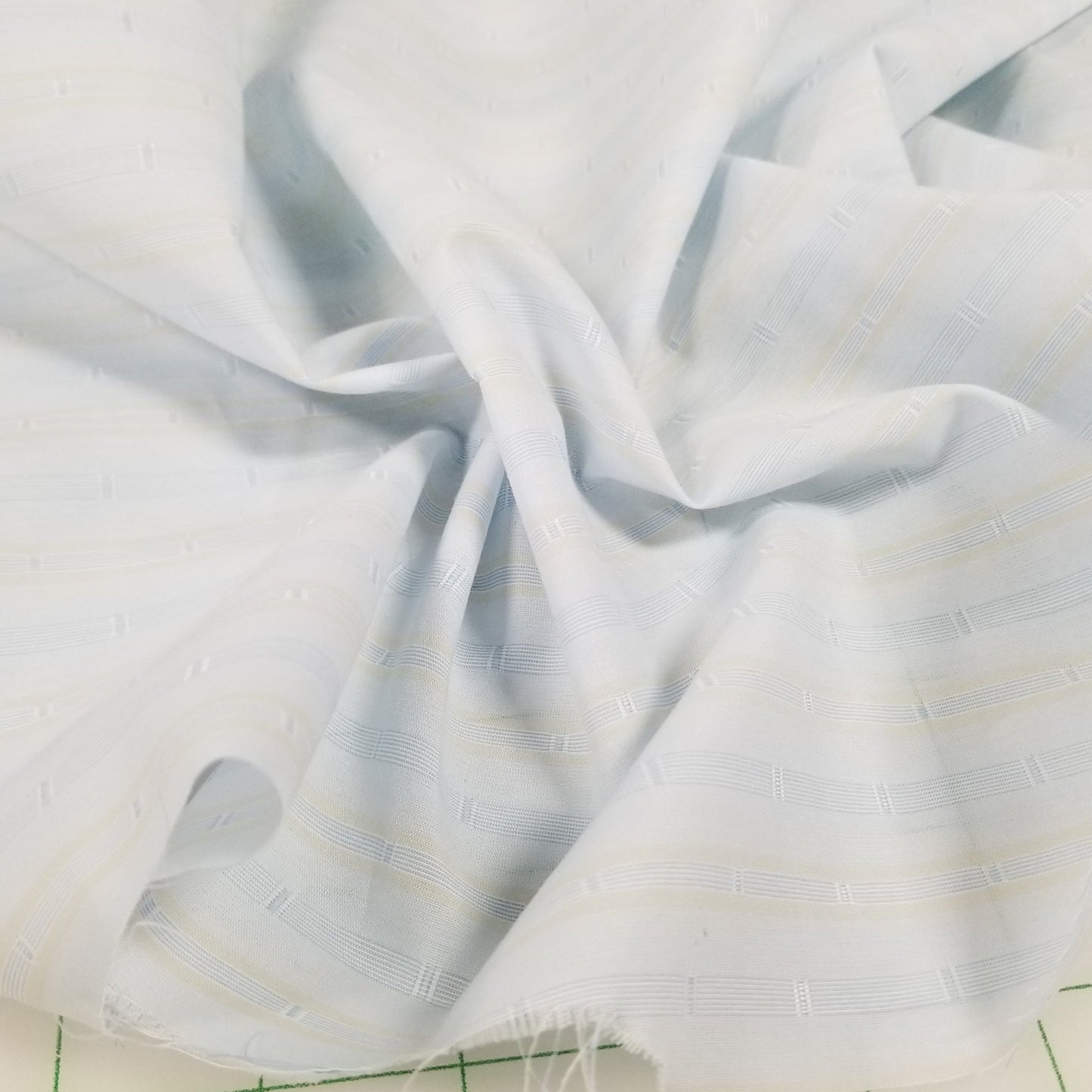 White fabric on a green grid background