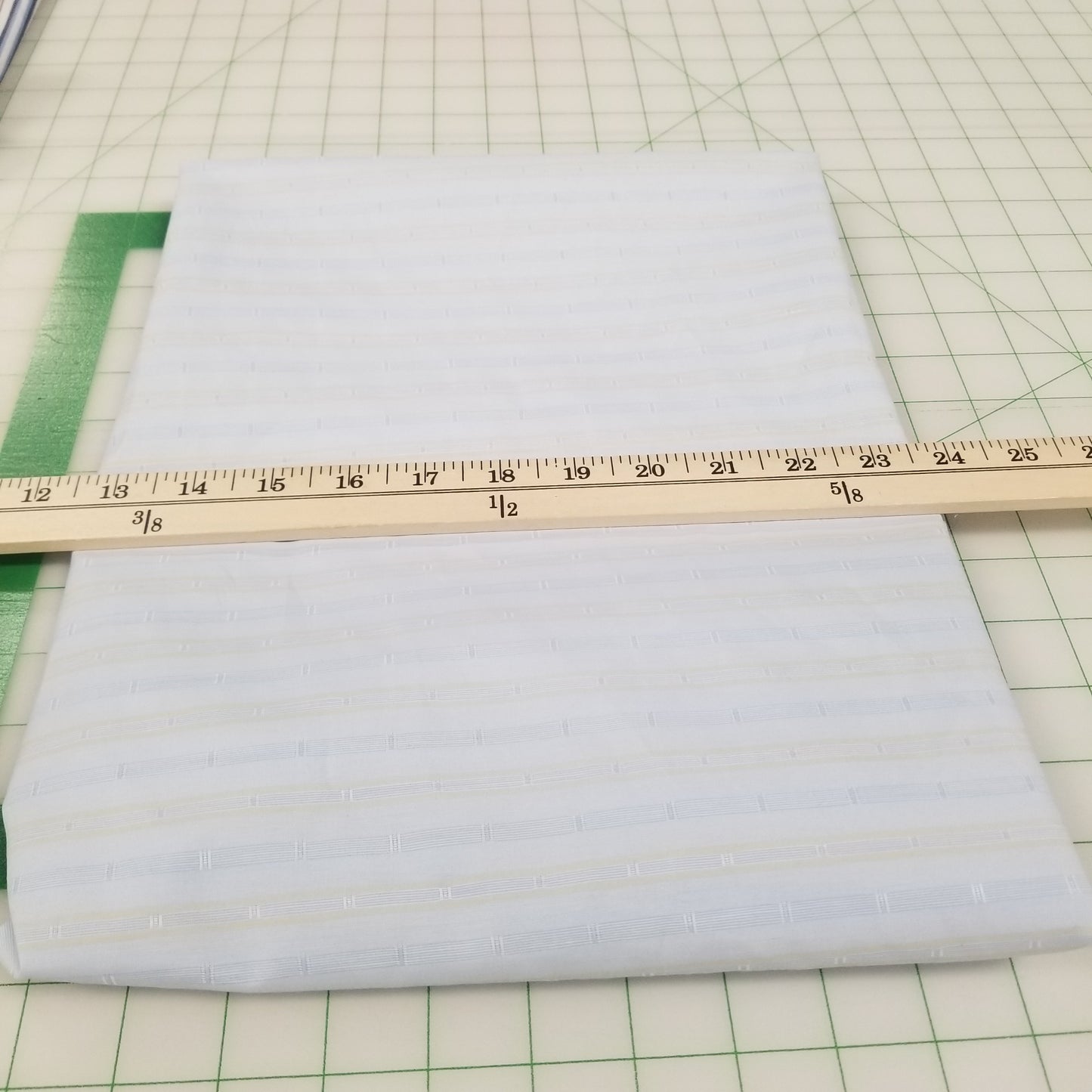 Sheet of white paper with a ruler on a green grid background