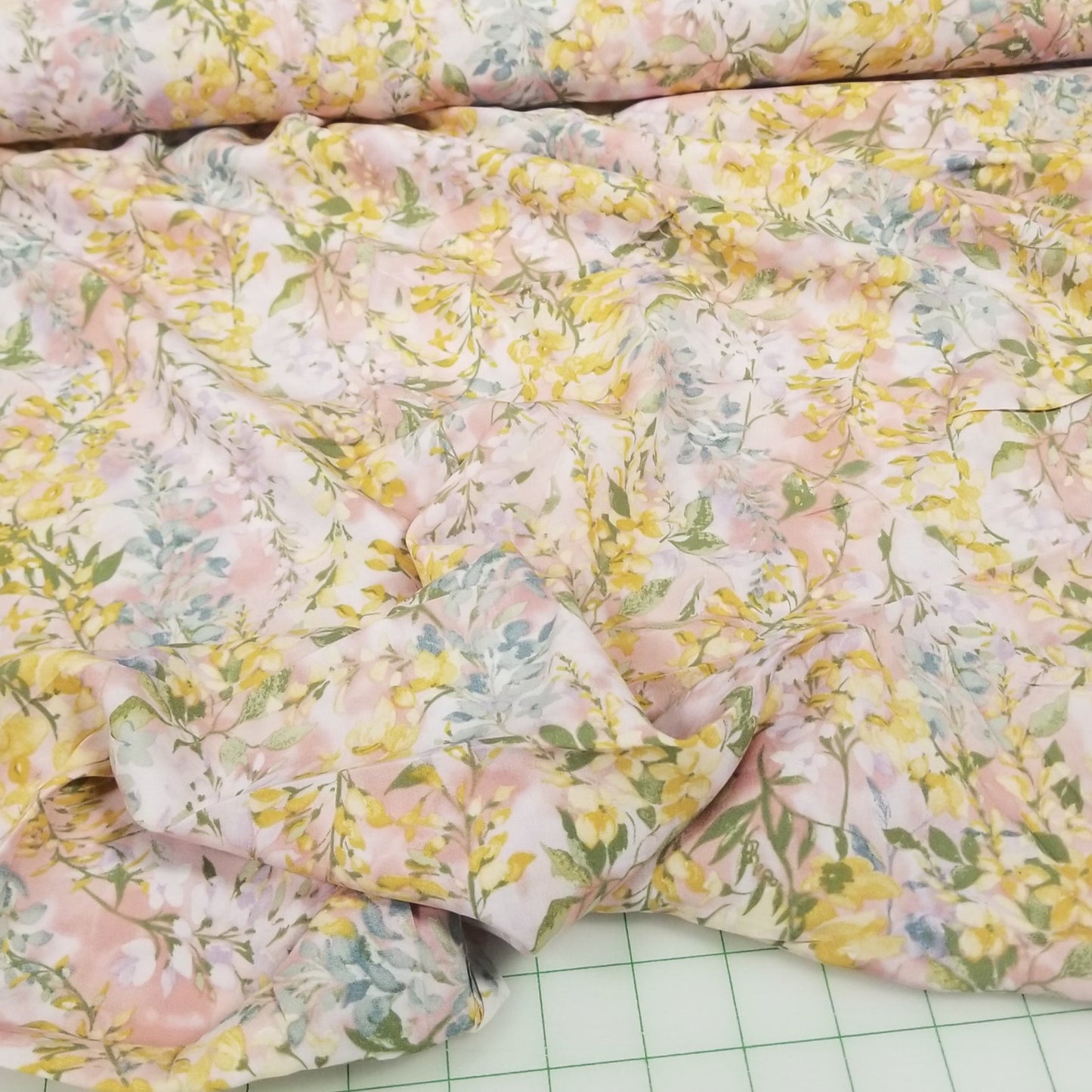 Floral fabric on a green cutting mat with grid lines
