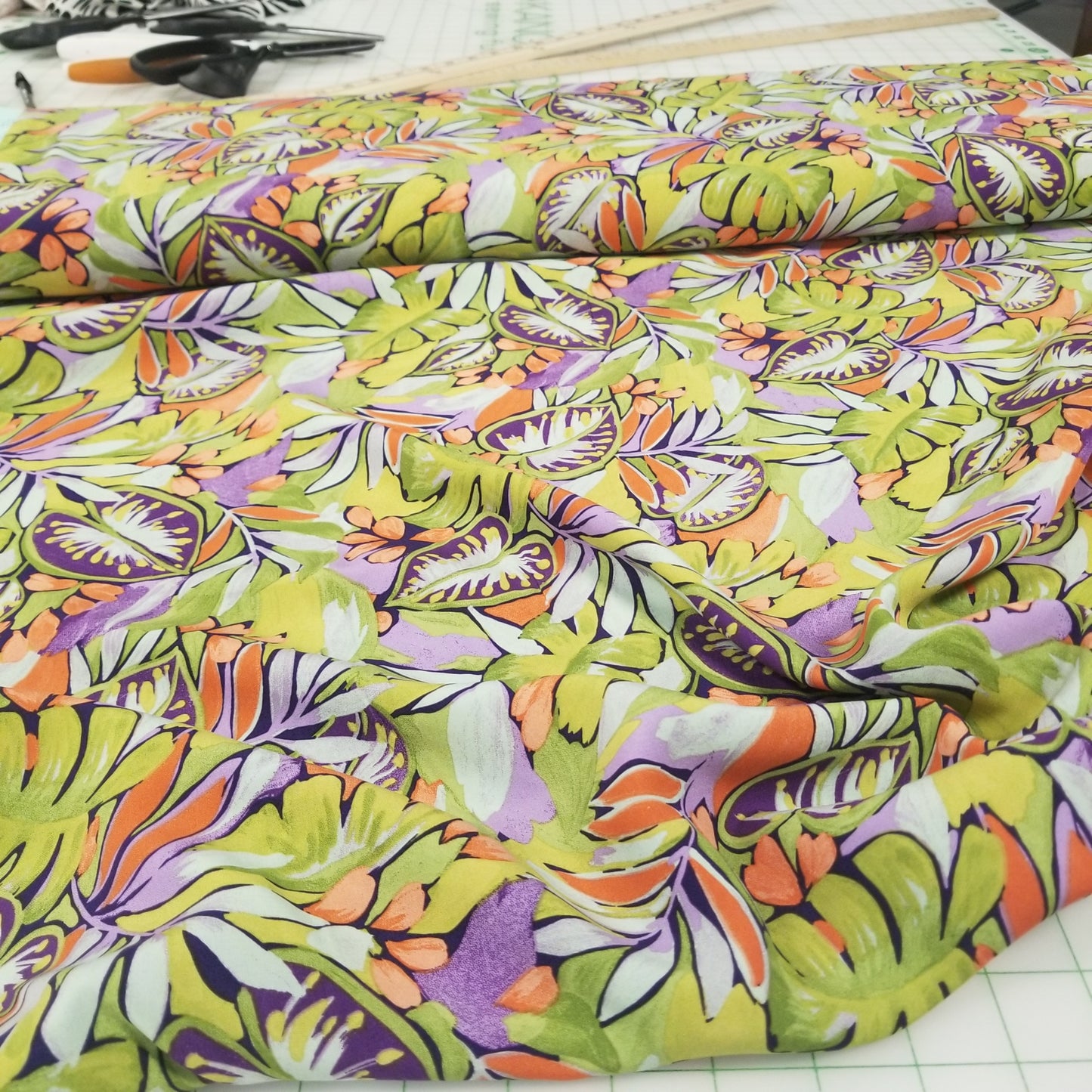 Colorful fabric with a leaf pattern on a cutting mat