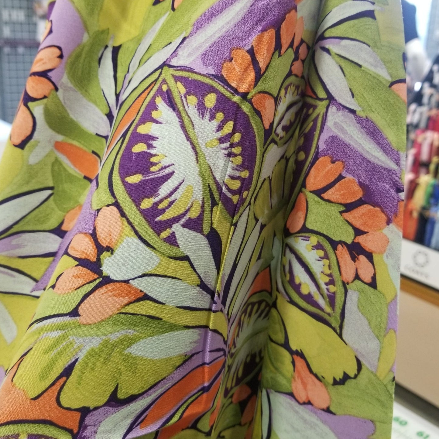 Roll of colorful fabric with a floral pattern in a store setting