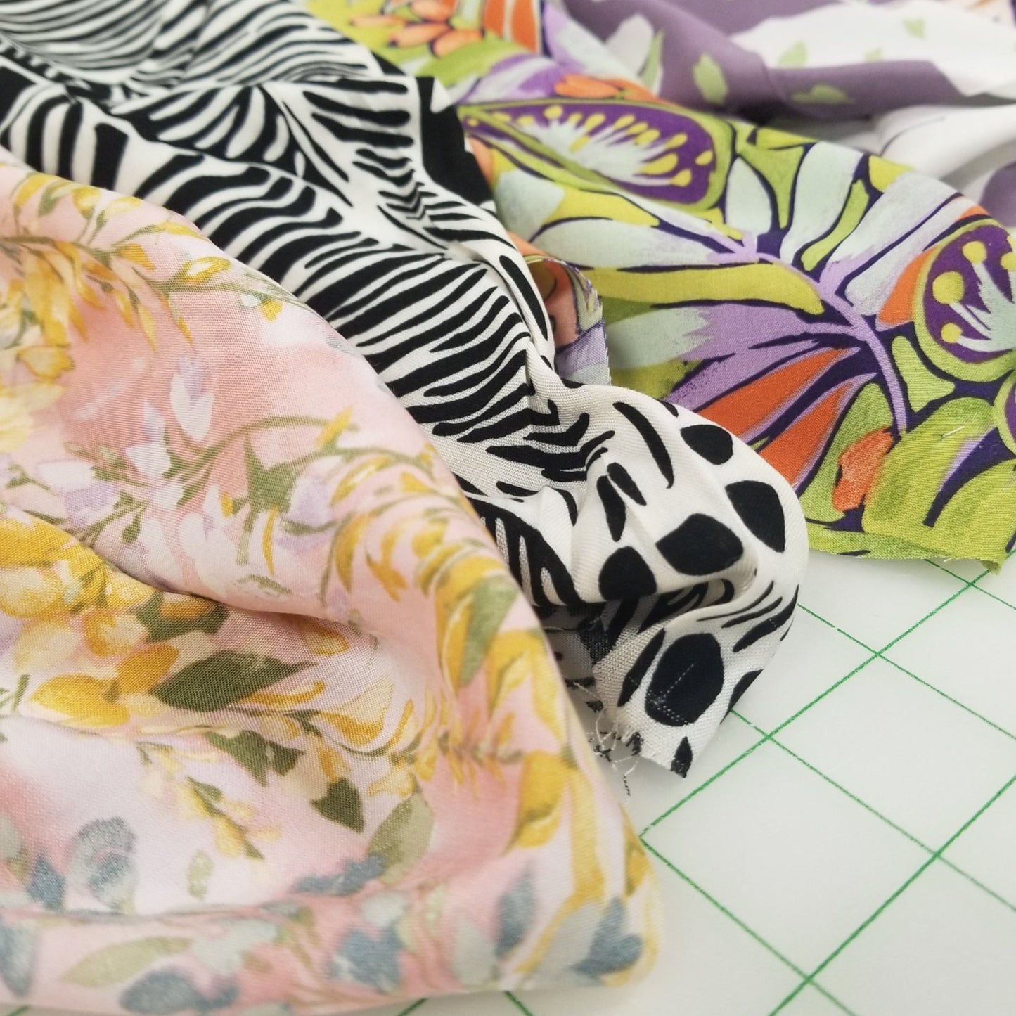 Fabric swatches with various patterns including floral, zebra, and abstract designs on a grid background.