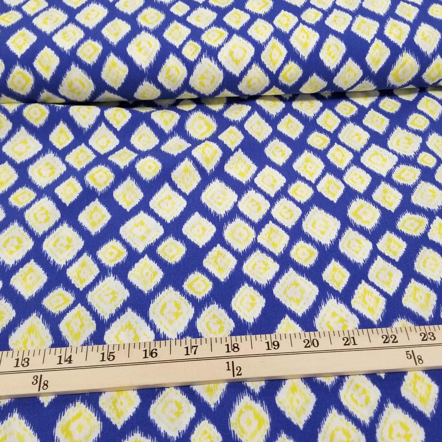 Blue fabric with yellow diamond pattern and a ruler for scale
