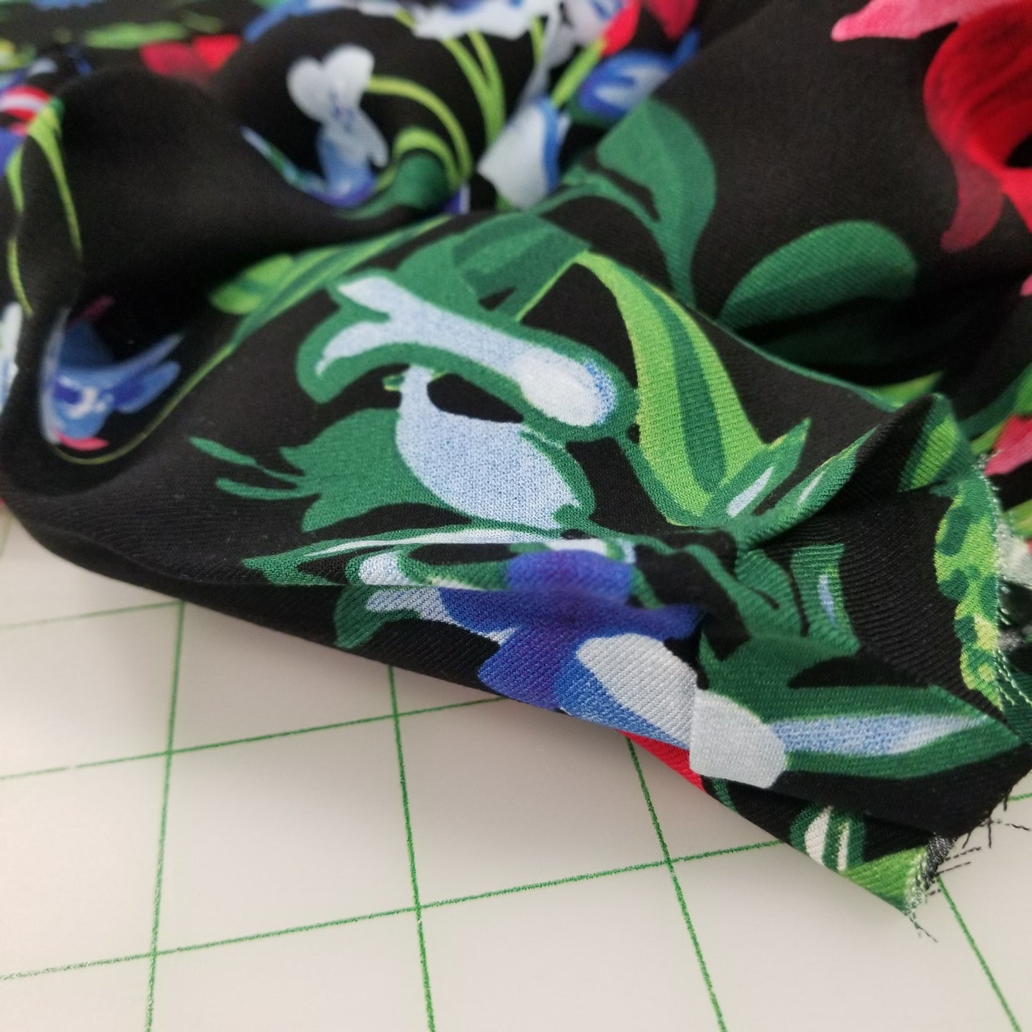 Close-up of a fabric with colorful floral pattern on a grid background