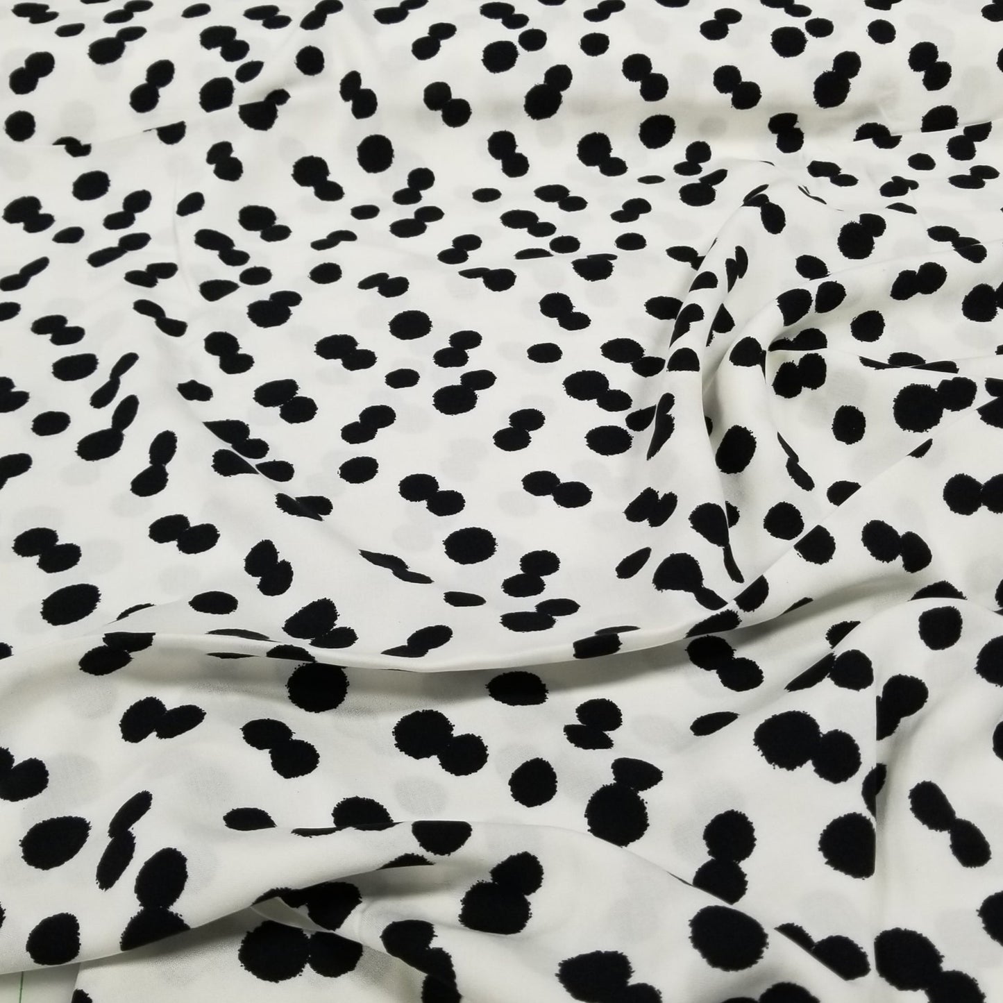 Fabric with black and white spotted pattern on a white background