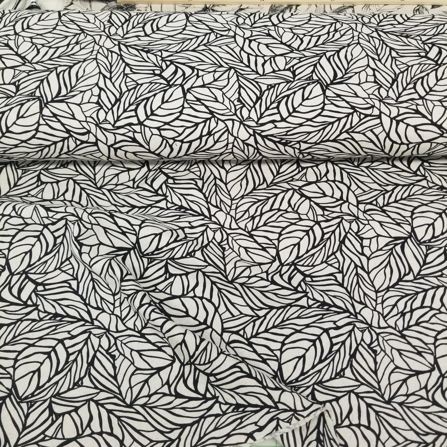 Black leaf pattern on a textured white background
