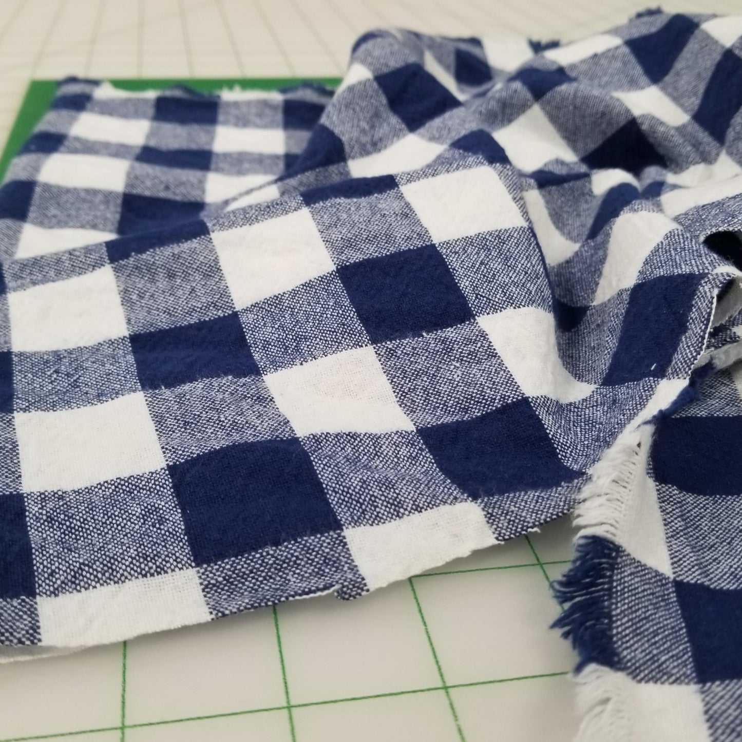 Blue and white checkered fabric on a cutting mat