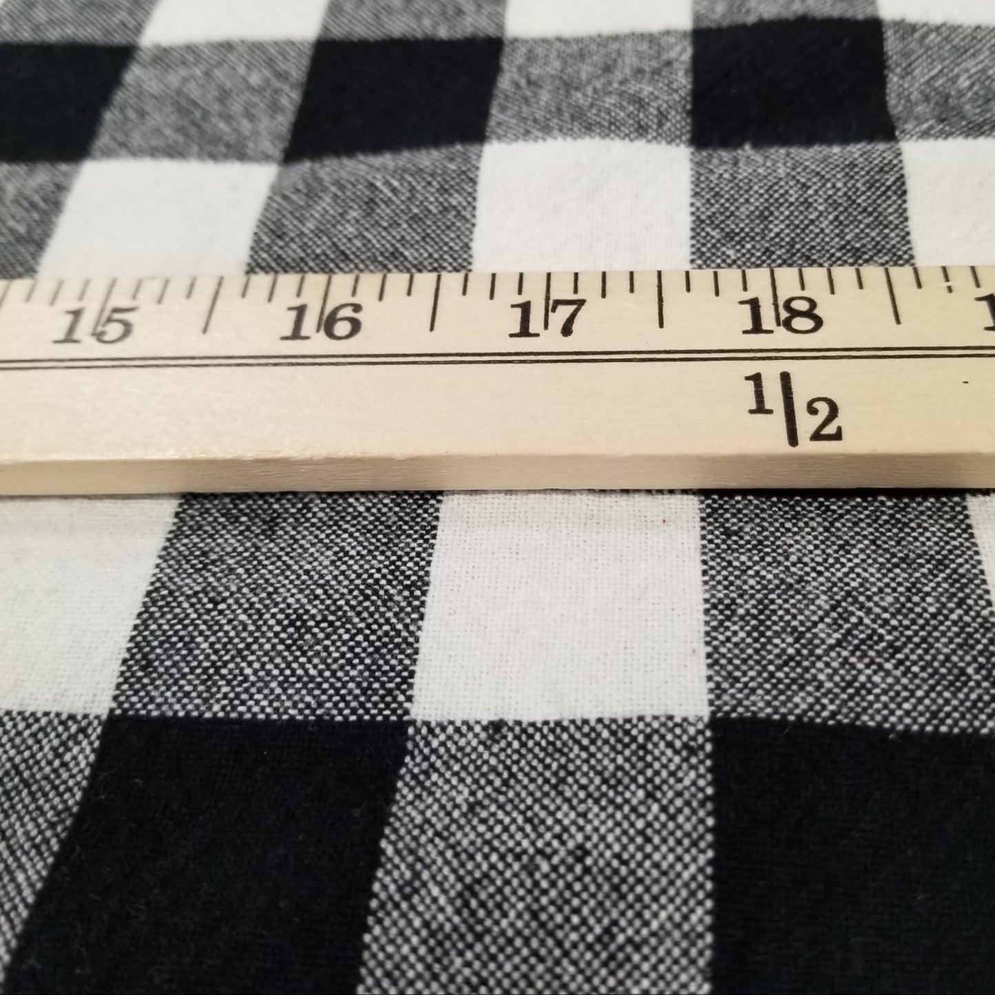 Black and white checkered fabric with a ruler for scale