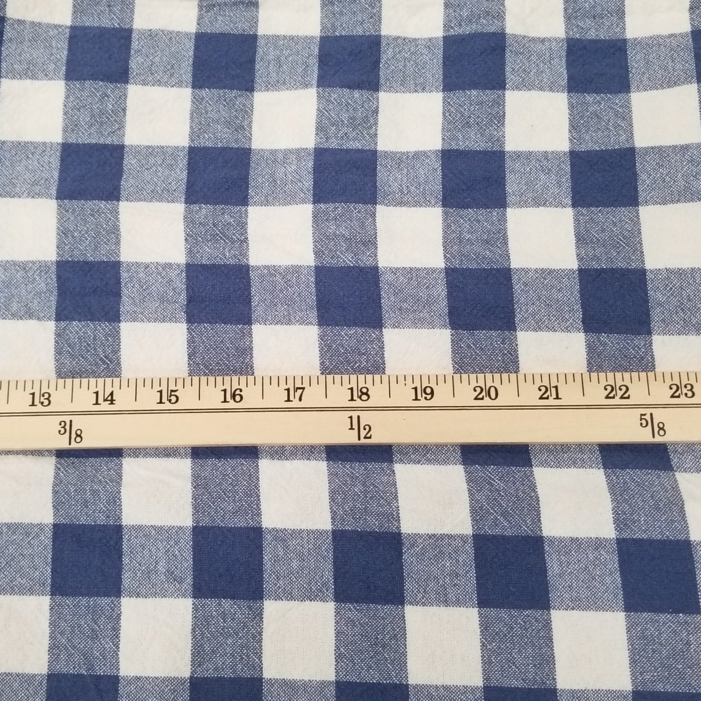 Blue and white checkered fabric with a ruler for scale on a green cutting mat.