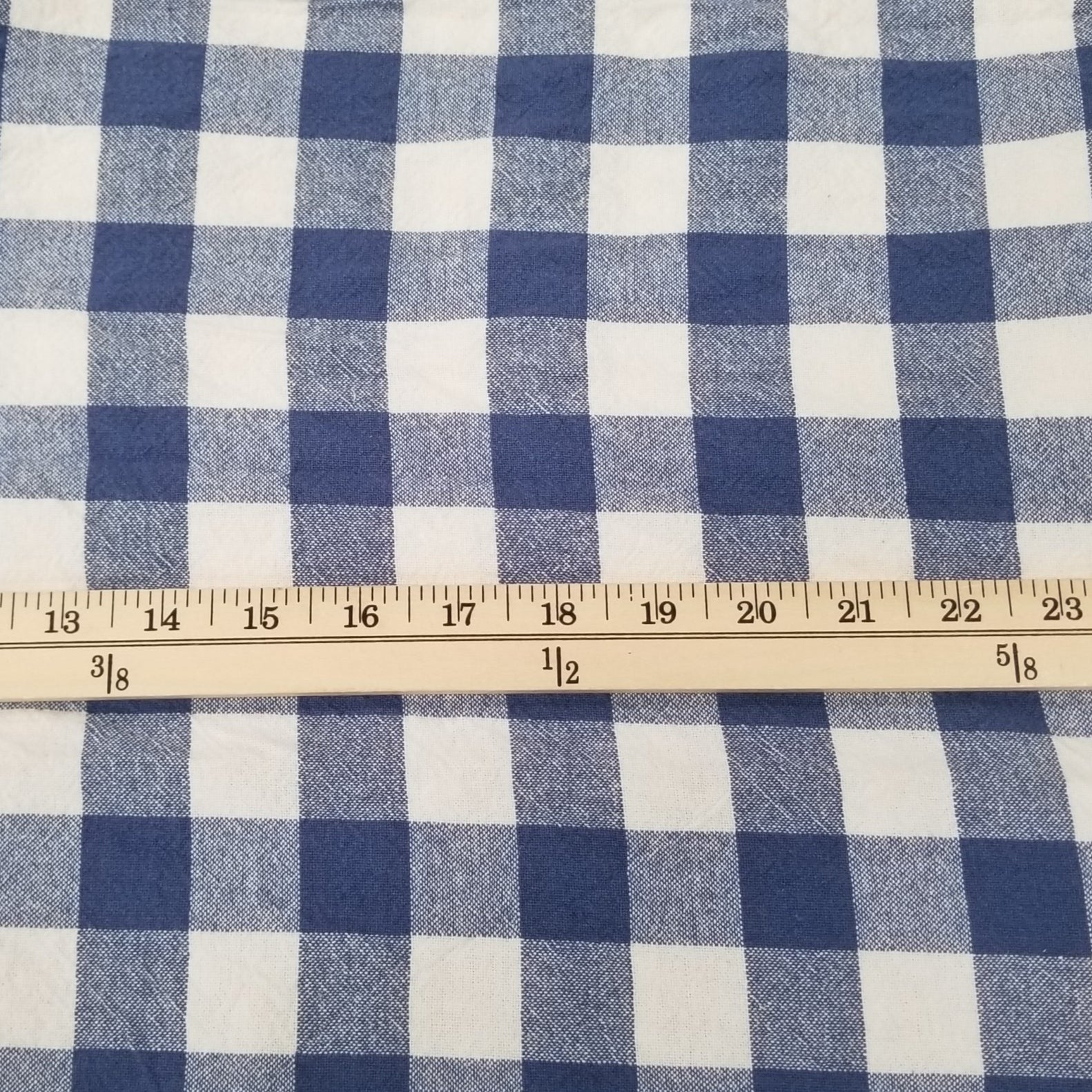 Blue and white checkered fabric with a ruler for scale on a green cutting mat.