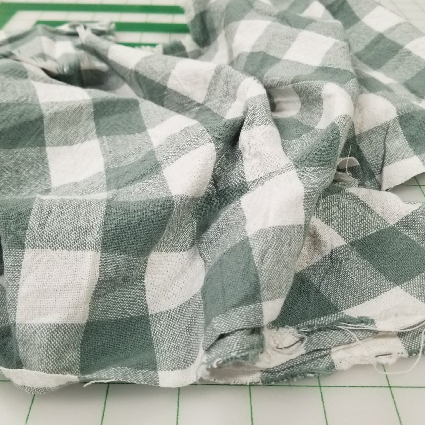 Green and white checkered fabric on a tiled floor