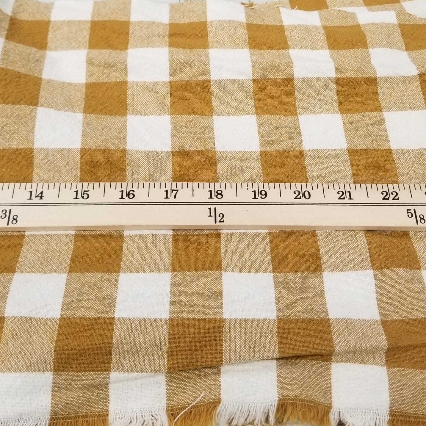 Brown and white checkered fabric with a ruler on a cutting mat