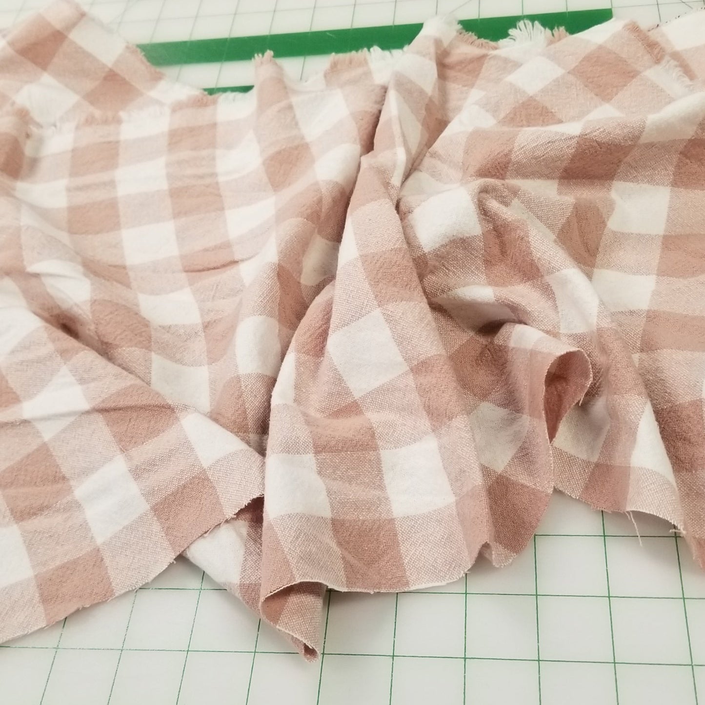 Pink and white checkered fabric on a green grid background