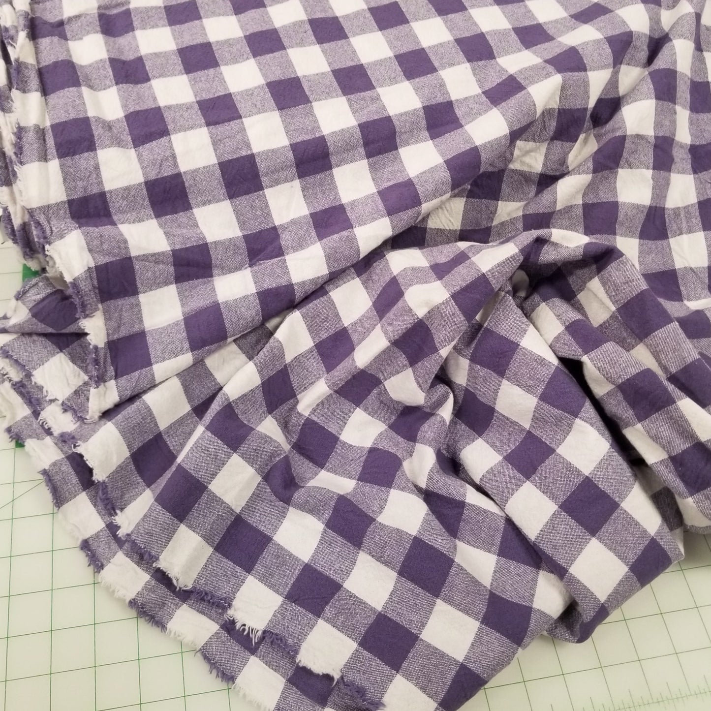 Purple and white checkered fabric on a green cutting mat