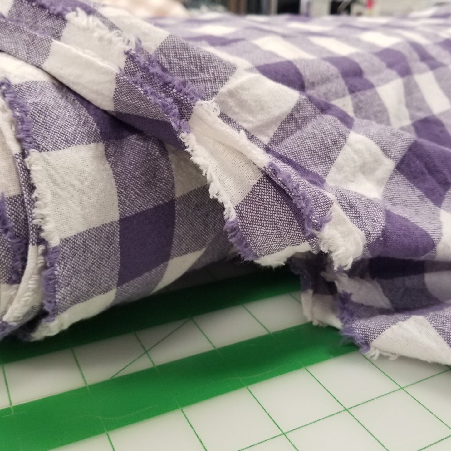 Purple and white checkered fabric on a green cutting mat