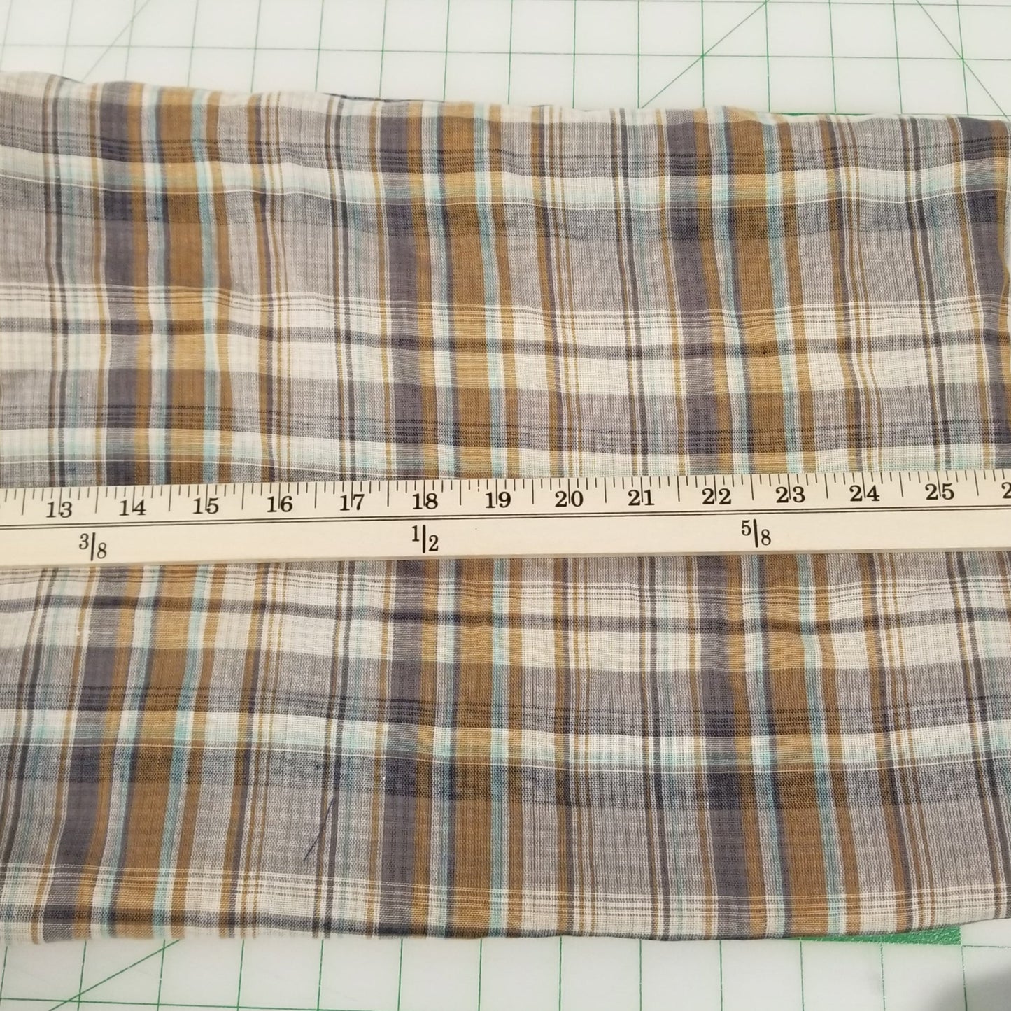 Plaid fabric with a ruler on a grid background