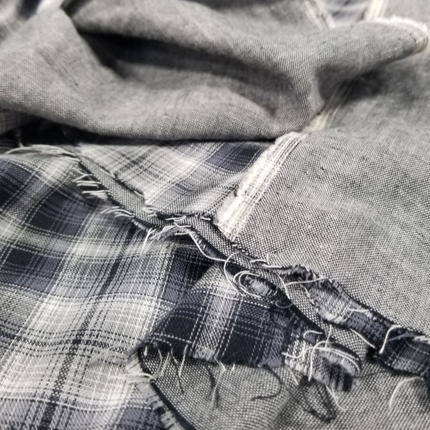 Close-up of a person wearing plaid overalls with a focus on the fabric texture.