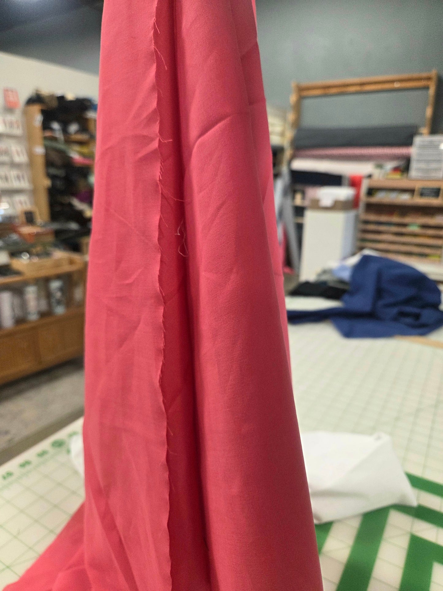 fuchsia fabric draped over a surface with a blurred indoor setting