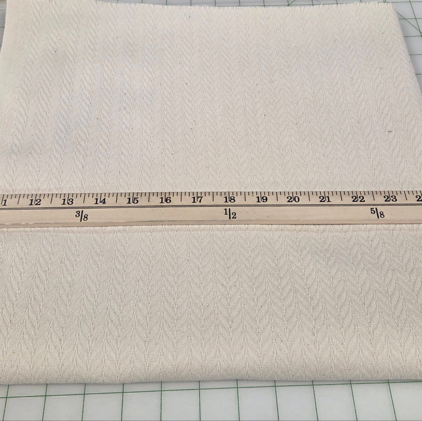 Beige fabric with a ruler on a grid background. LA Finch Fabric