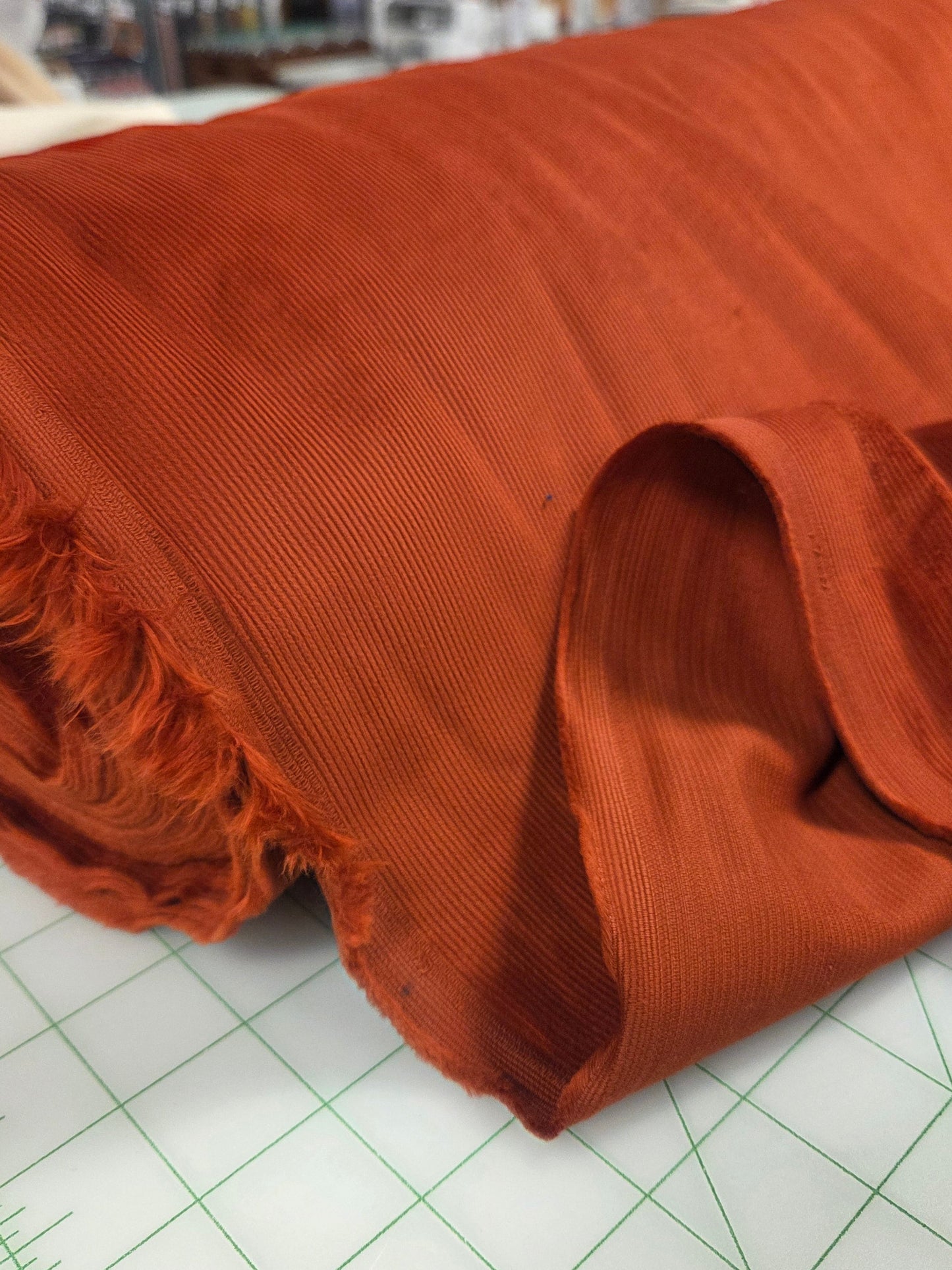Brown fabric on a cutting mat with grid lines