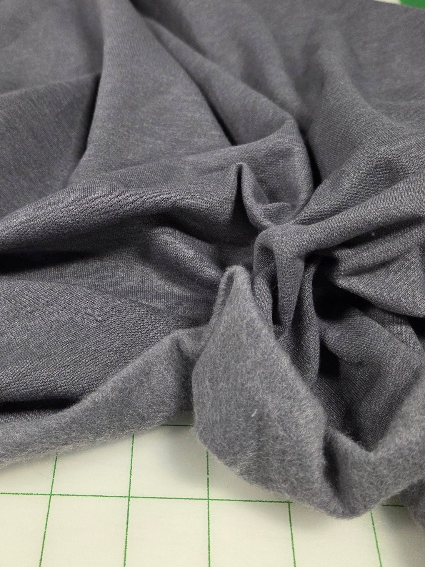 Gray fabric draped over a surface with a grid background