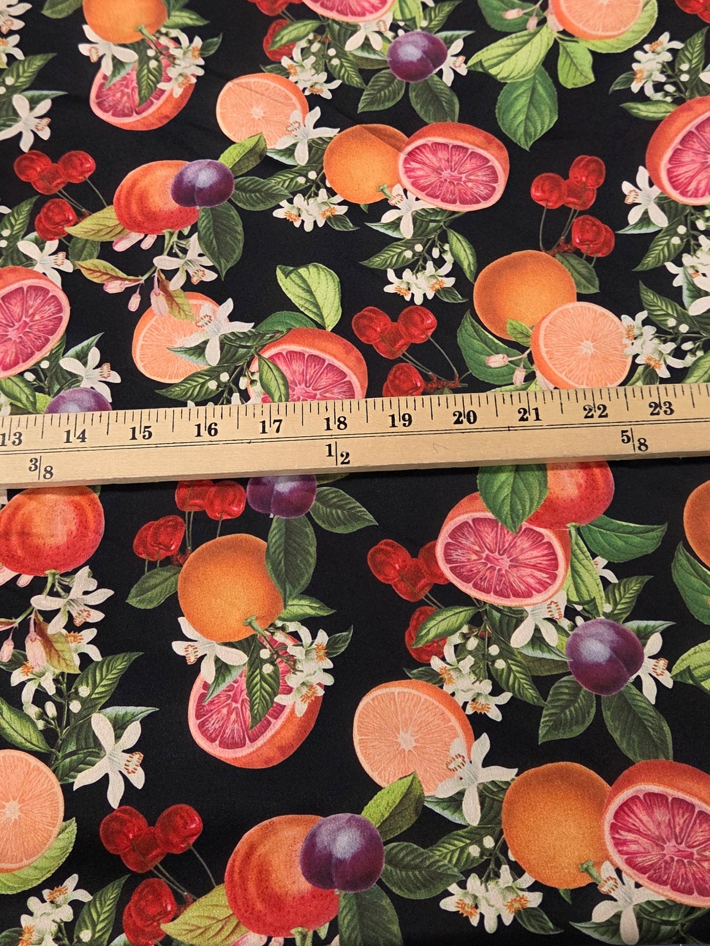 Fabric with fruit pattern on a cutting mat with a ruler