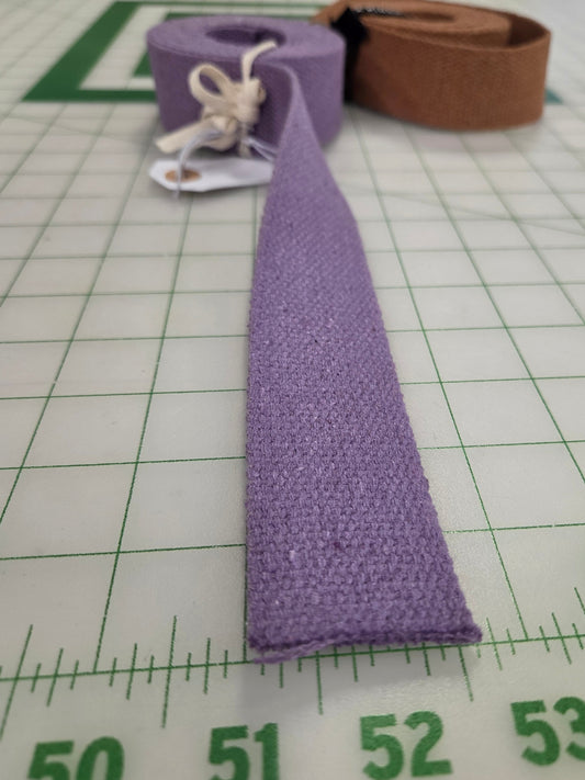 Purple fabric strip with white drawstring on a green grid cutting mat.