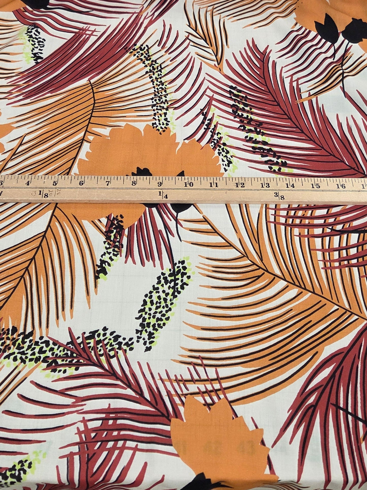 Fabric with a floral pattern and a ruler for scale , rayon voie tropical for sewing your own fabric