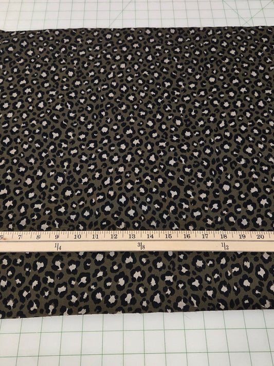 Fabric with a pattern on a cutting mat with a ruler and scissors.