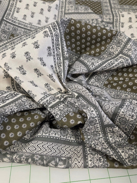 Patterned fabric with geometric and floral designs on a grid background