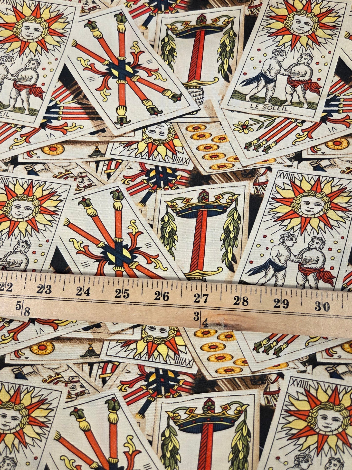 Collection of tarot cards with a ruler for scale