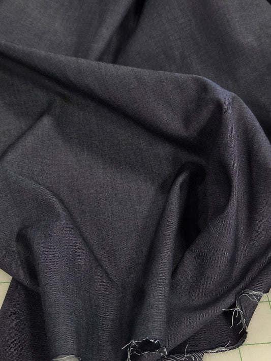 Dark gray fabric on a cutting mat with grid lines