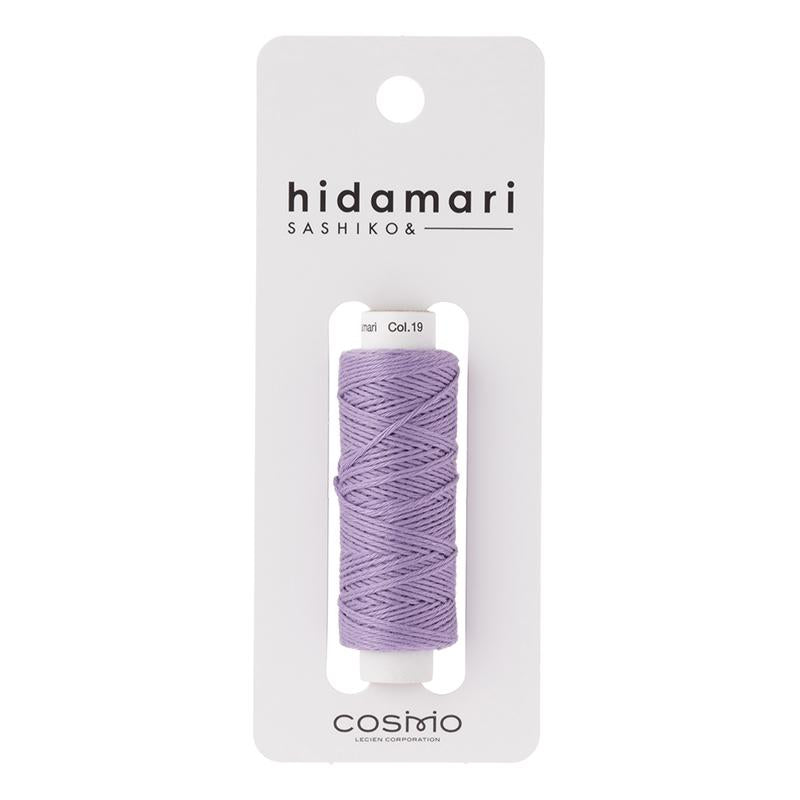 Purple thread spool in a 'hidamari' packaging on a white background