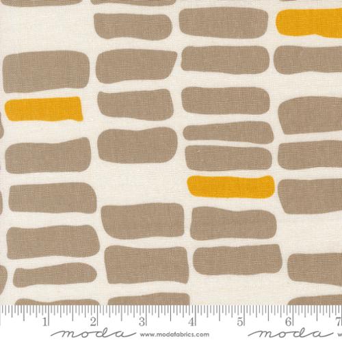 Fabric pattern with brown and yellow shapes on a white background, featuring Moda label.