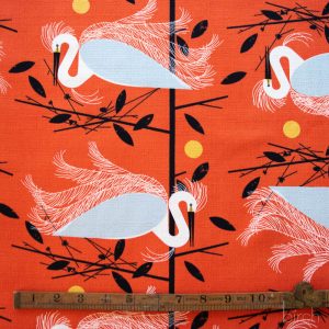 Flamingo pattern on an orange background with a ruler for scale. Charley Harper Fabric by the half yard
